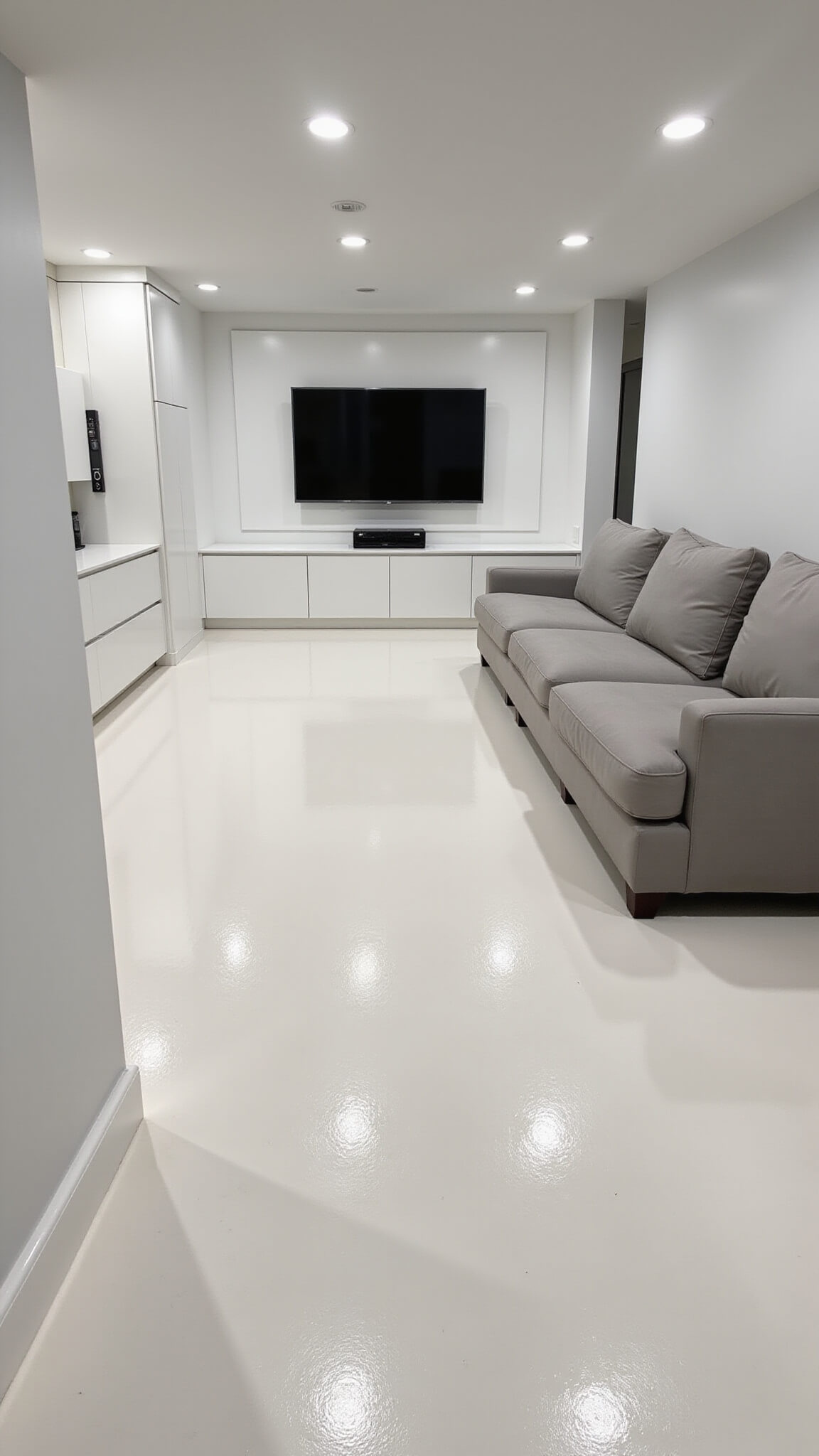 Modern minimalist 850 sq ft basement with white epoxy floors, recessed LED lighting, built-in matte white storage, hidden dehumidifiers, smart home controls, and light grey furniture.