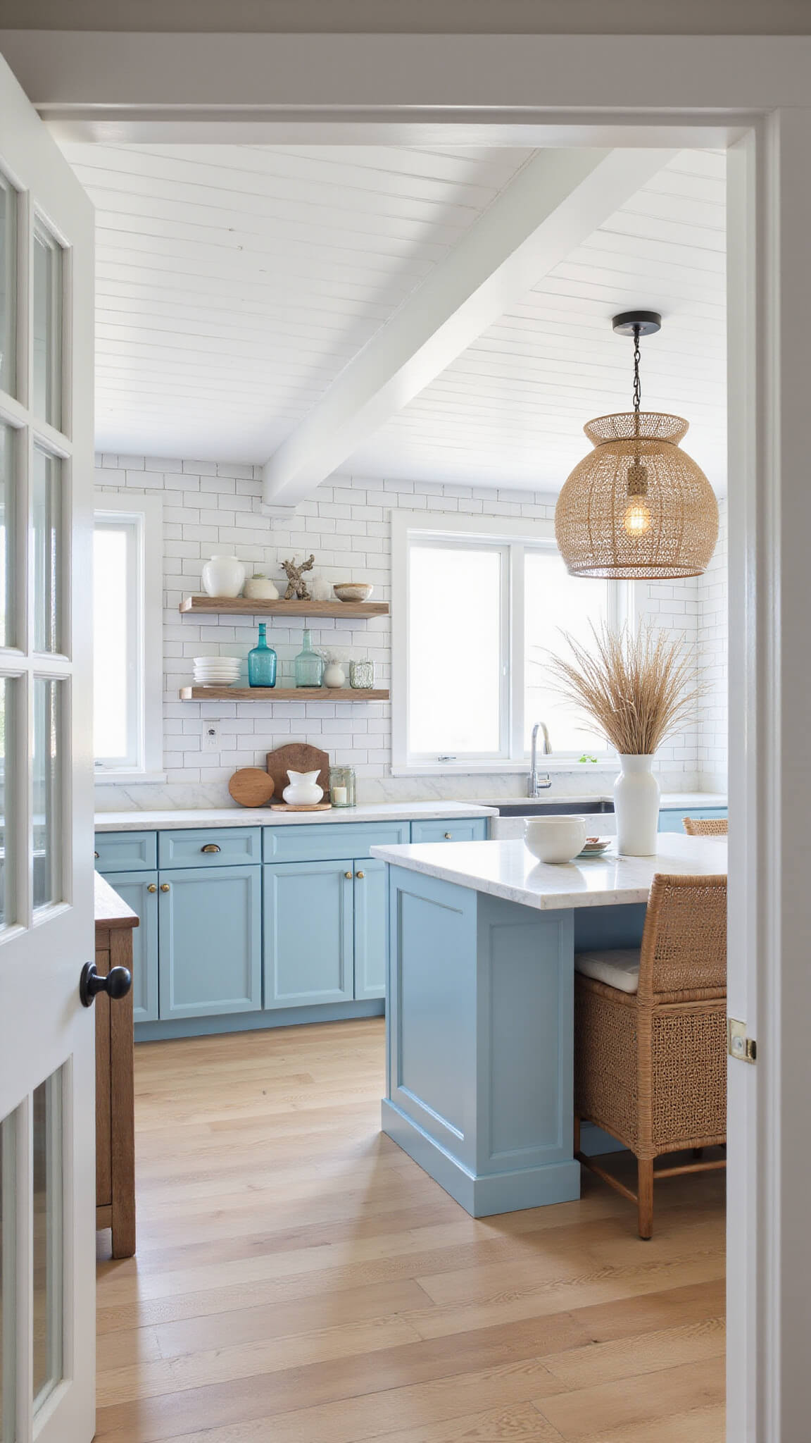 Airy coastal kitchen with sky blue cabinets, shiplap ceiling, rattan lights, and beach-inspired decor.
