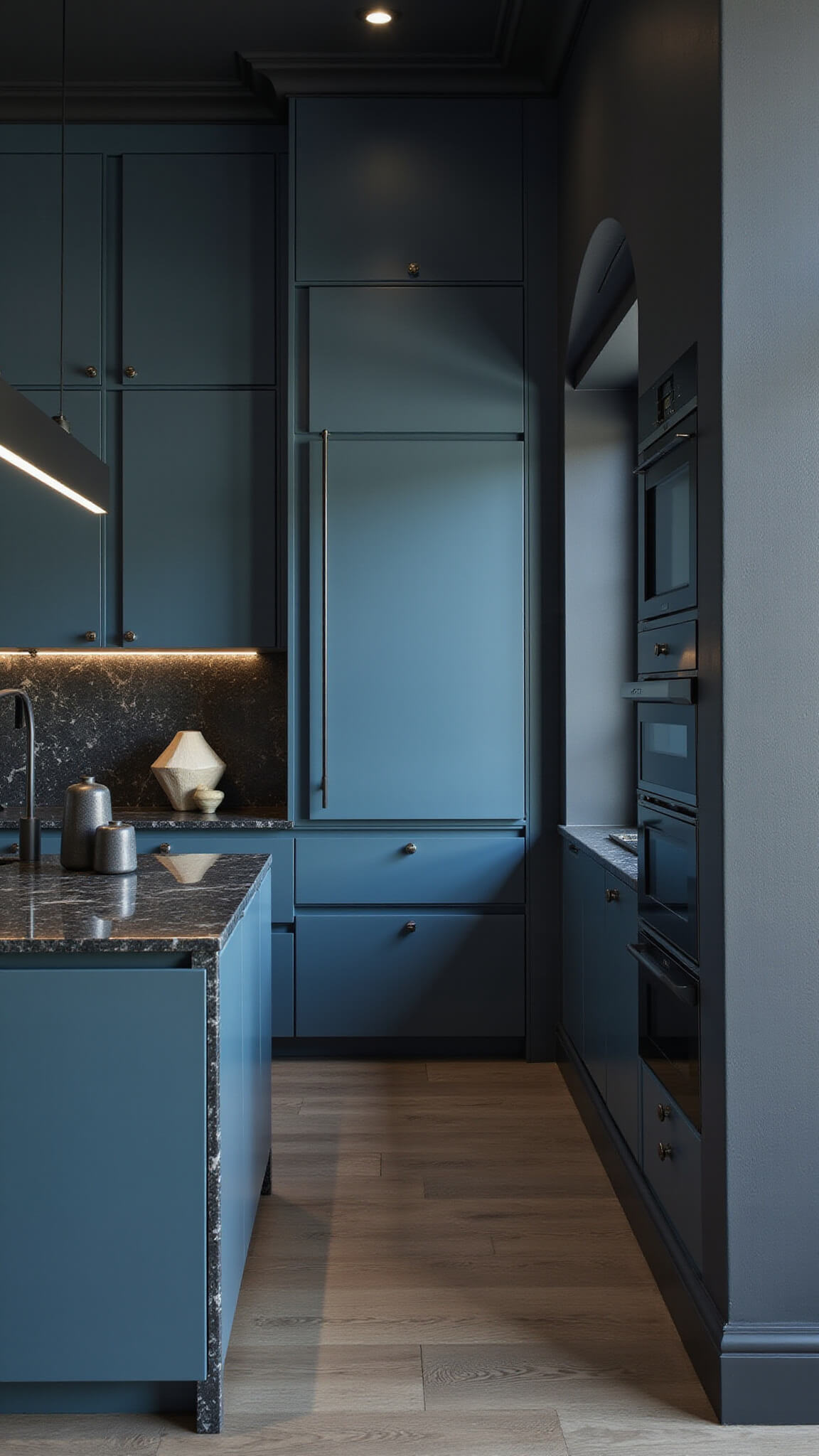 Low-angle view of a dramatic contemporary kitchen with teal high-gloss cabinets, Negro Marquina marble waterfall island, matte black fixtures, and moody LED uplighting.