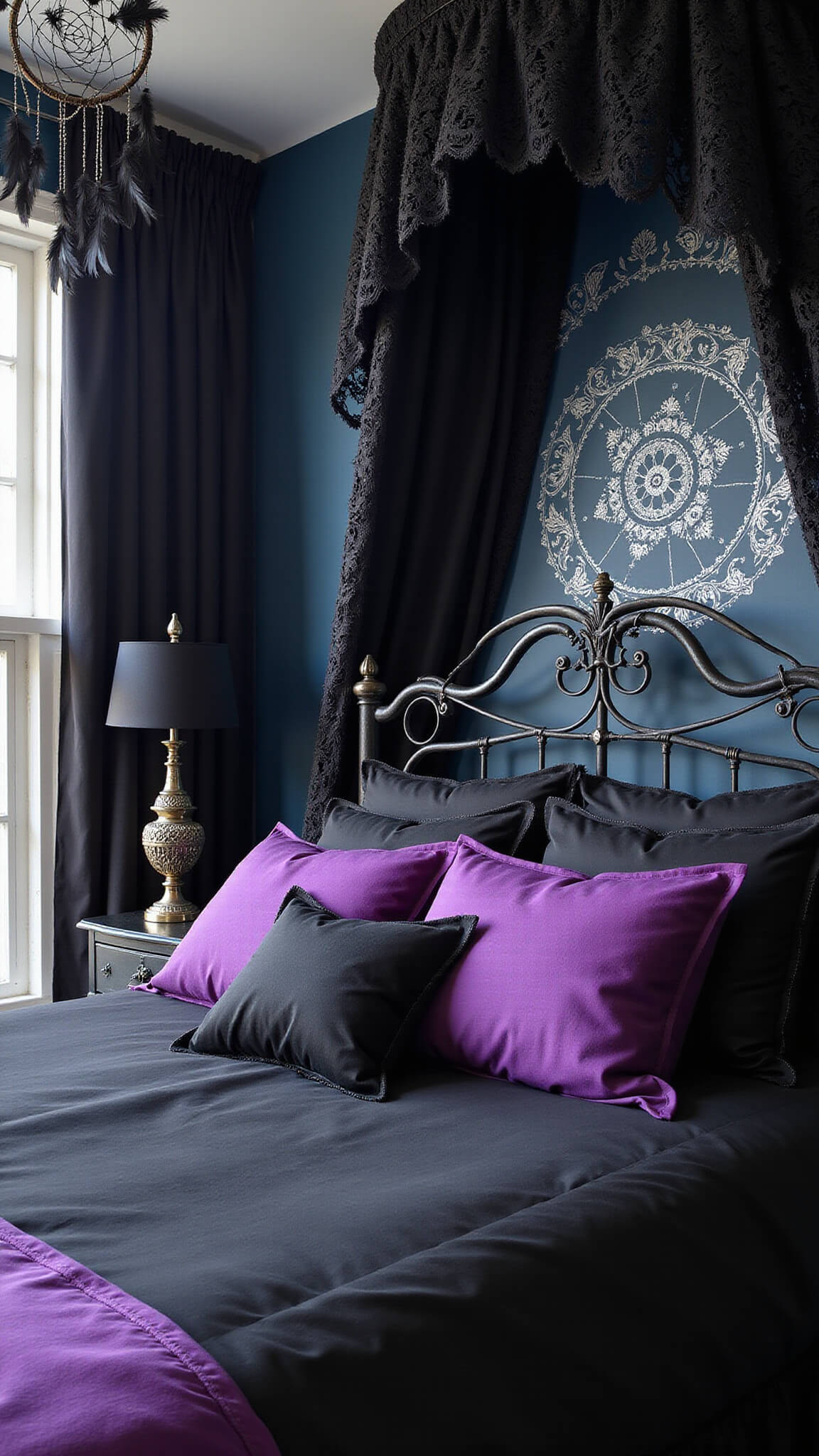 High-angle view of a gothic-style king bed with black silk sheets, purple velvet comforter, silver-threaded pillows, and black lace canopy, set against a midnight blue wall with silver stenciling and gothic lamps.