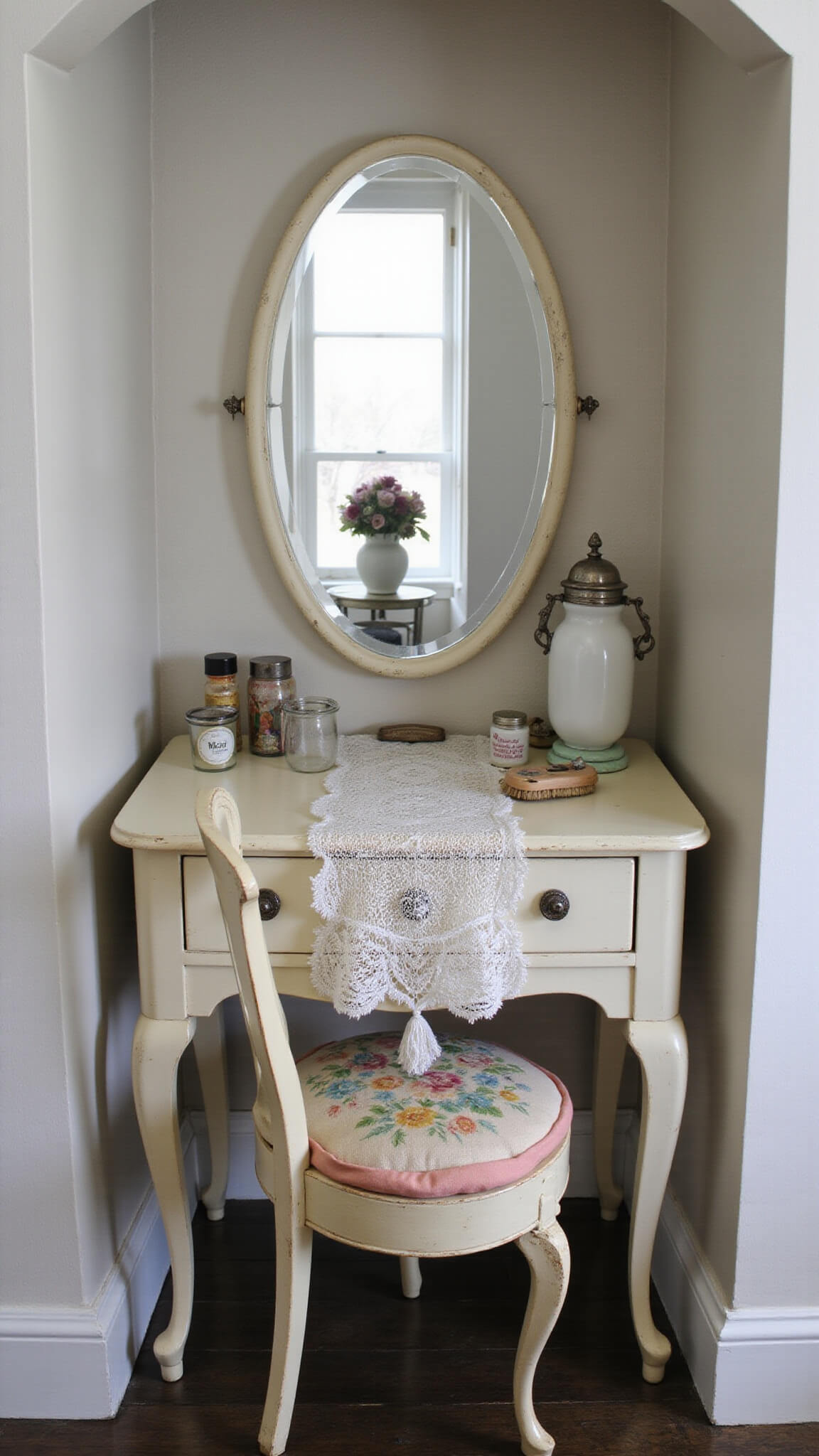 Art deco vanity in cream with vintage accessories and lace runner, softly lit in a cozy alcove.