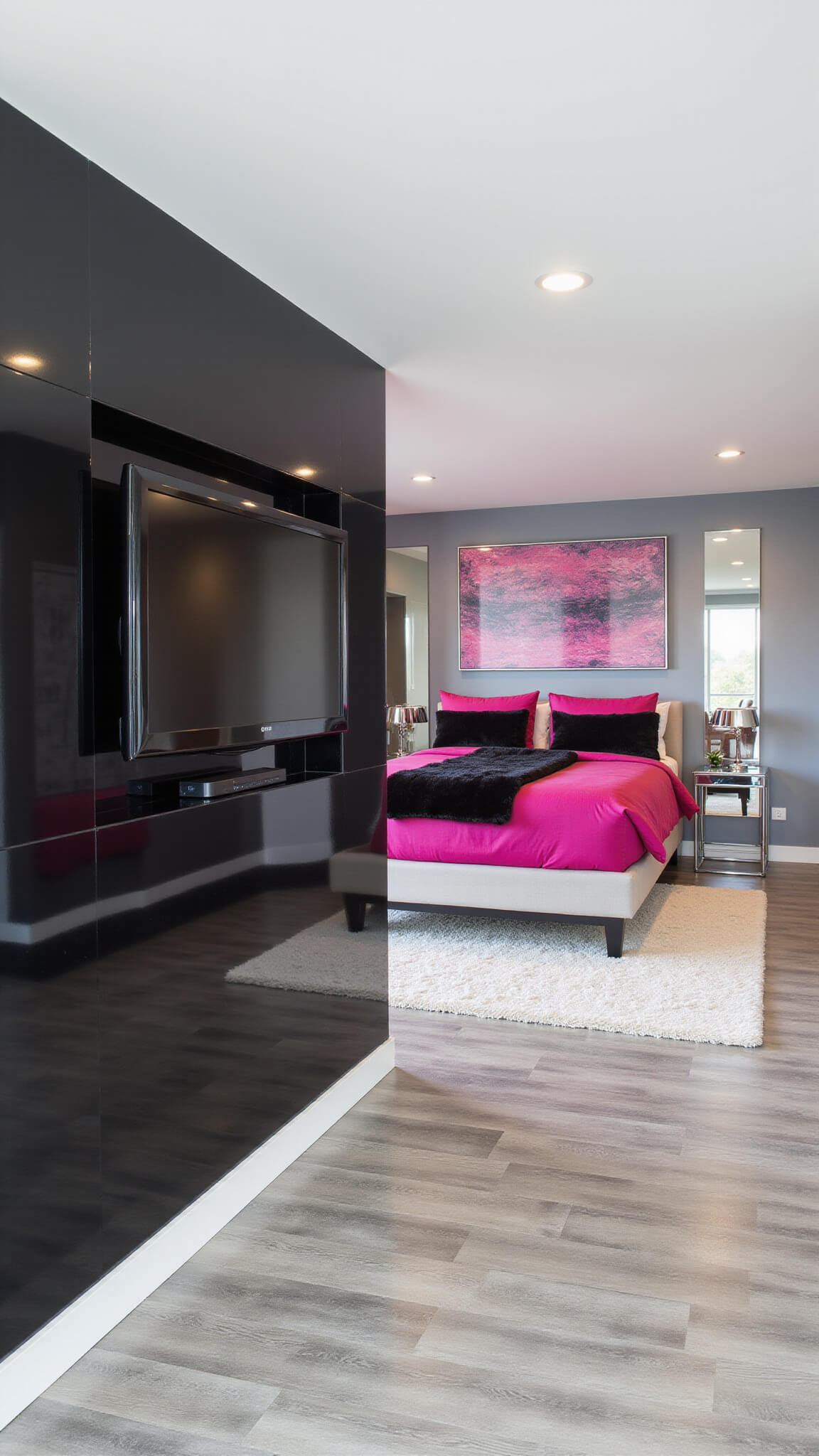 Contemporary 16x18ft primary suite with glossy black feature wall, hot pink bedding on platform bed, chrome and glass accents, abstract pink and black art, and gray wash hardwood floors, viewed diagonally from entrance.