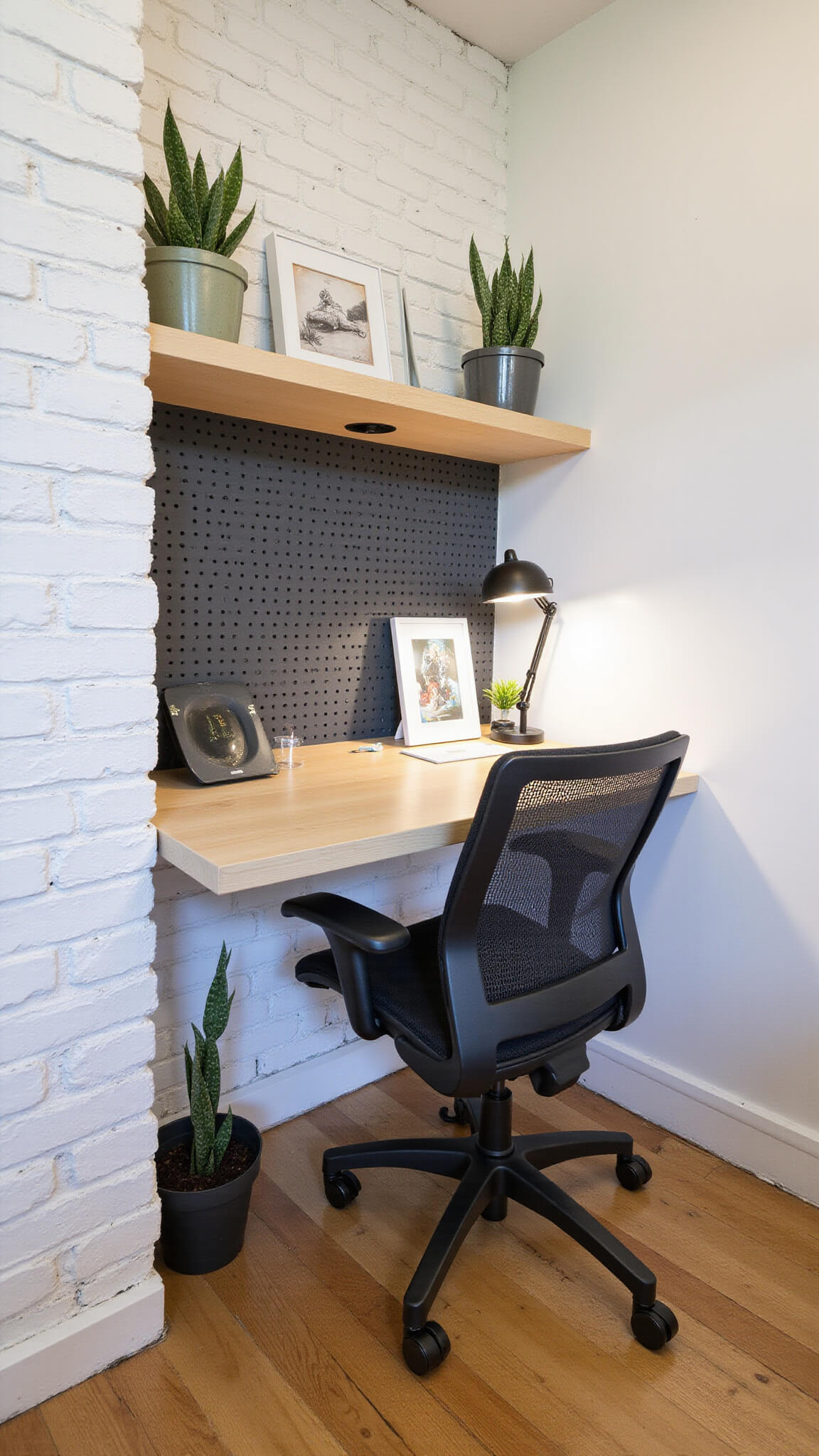 Compact 5x7ft home office nook with floating bleached oak desk, pegboard storage, ergonomic mesh chair, and white brick wall with snake plants.