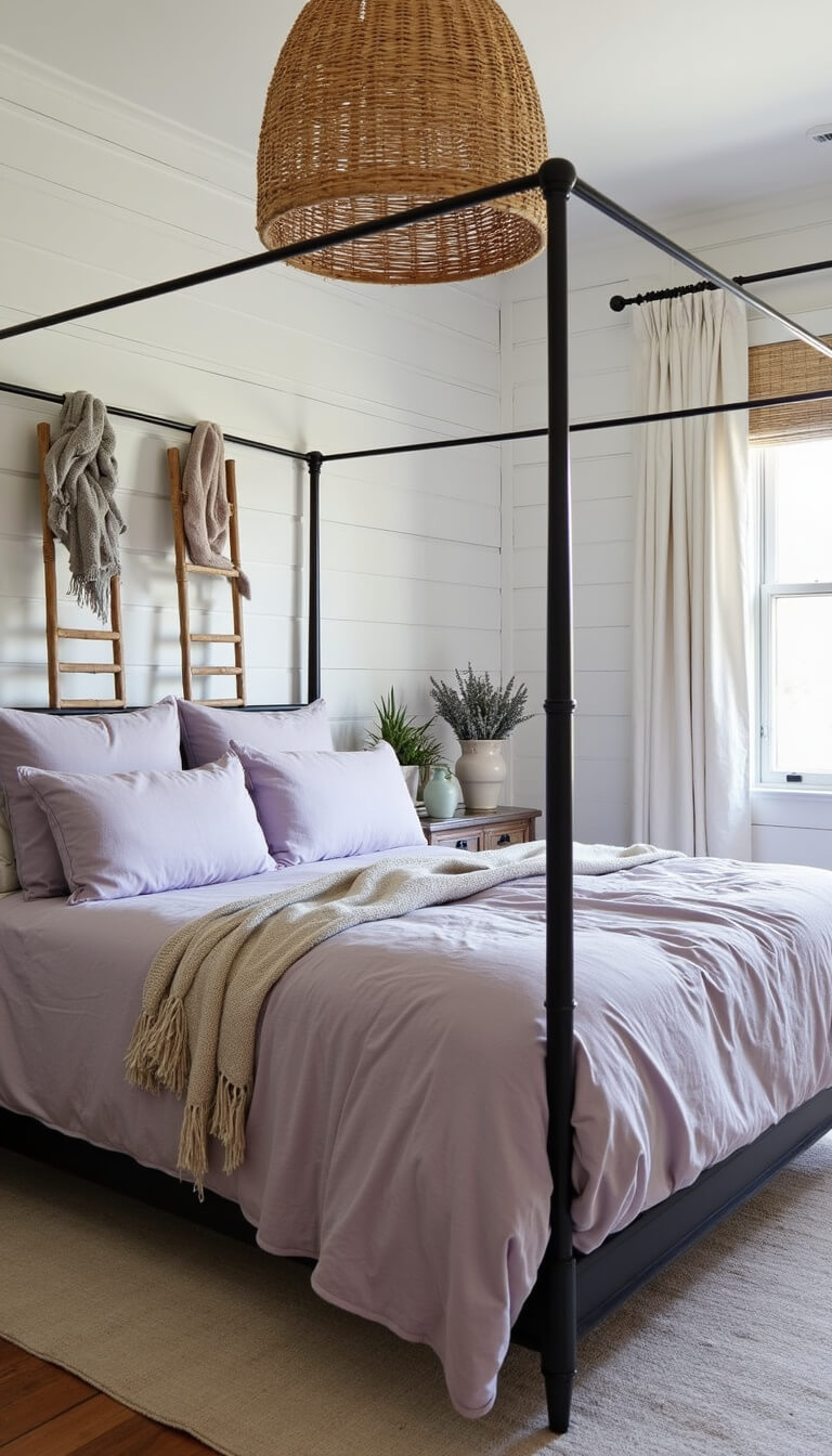 Modern farmhouse bedroom with soft white shiplap wall, iron canopy bed in lavender linens, vintage ladder with throws, rattan pendant light, and ceramic vases of dried lavender.